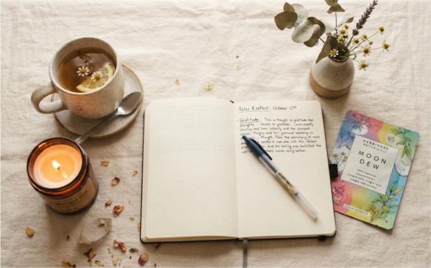 sunday reset routine flat lay with candle journal and skincare